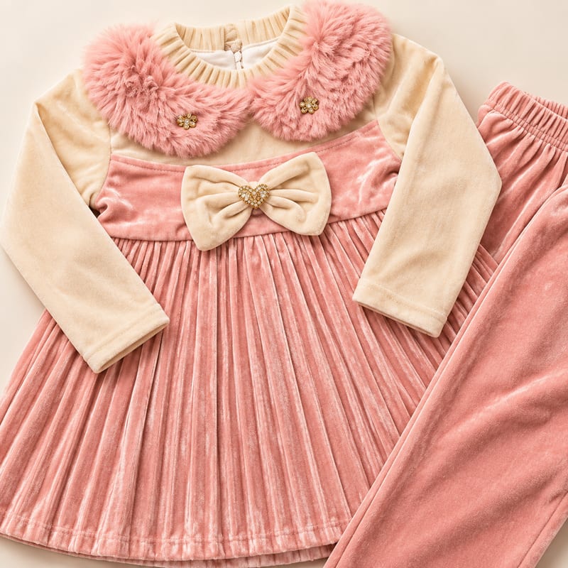 Close-up of the pink faux-fur collar, heart-brooch bow and pleated velvet skirt